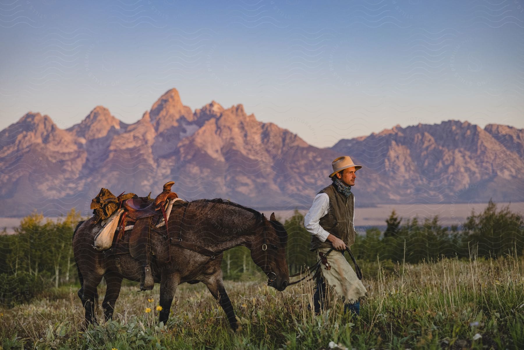 A man walking a horse outdoors in a grass field