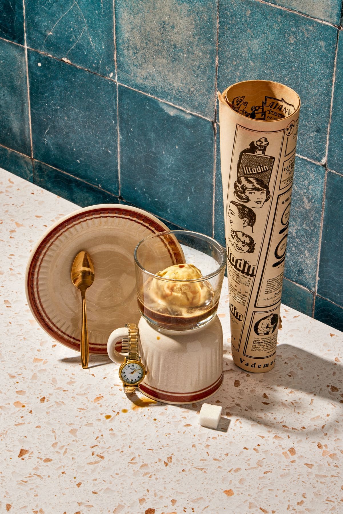 A glass see-through cup is placed on a teacup with objects strategically placed in random.