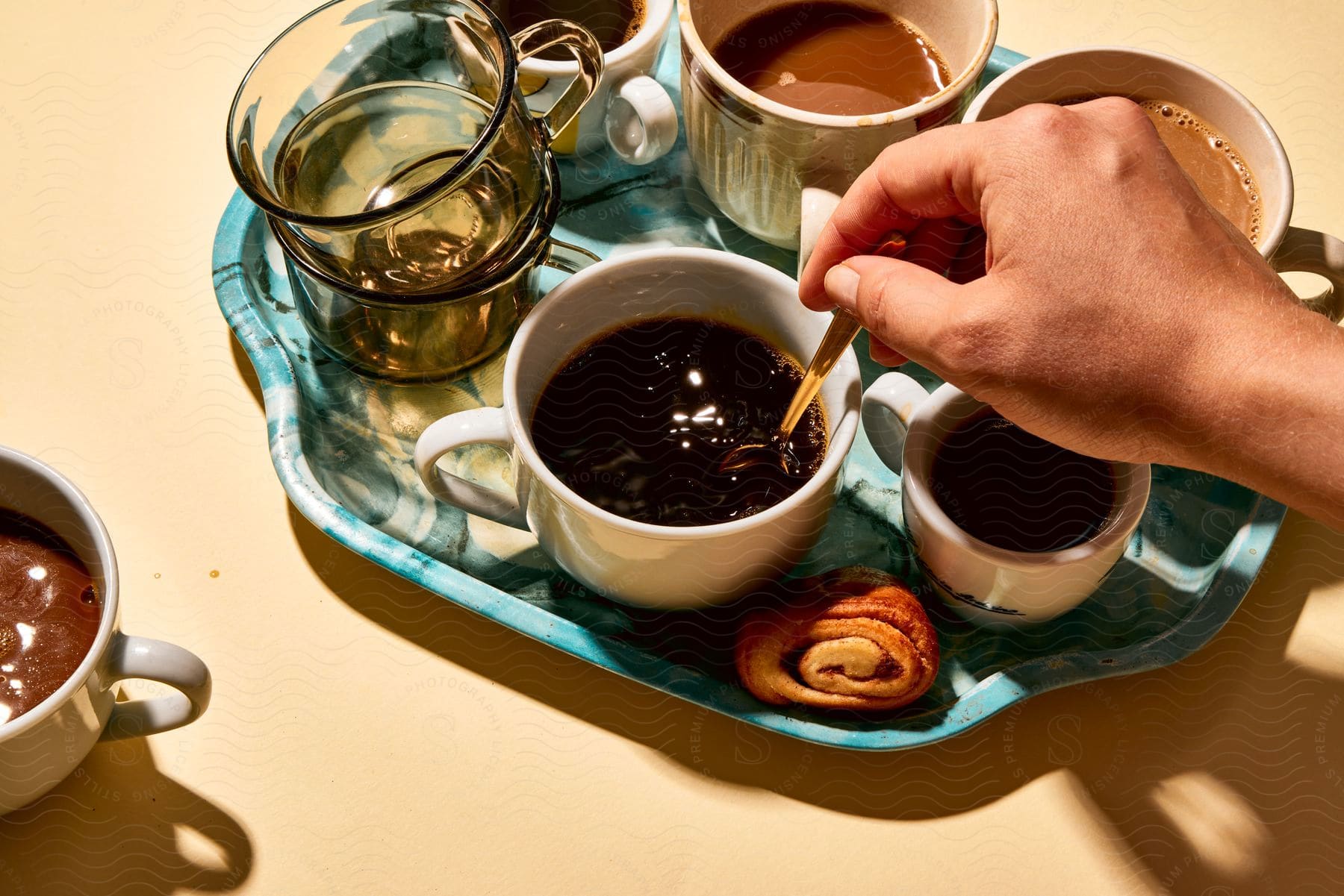 Stock photo of a person stirring tea sitting on a tray