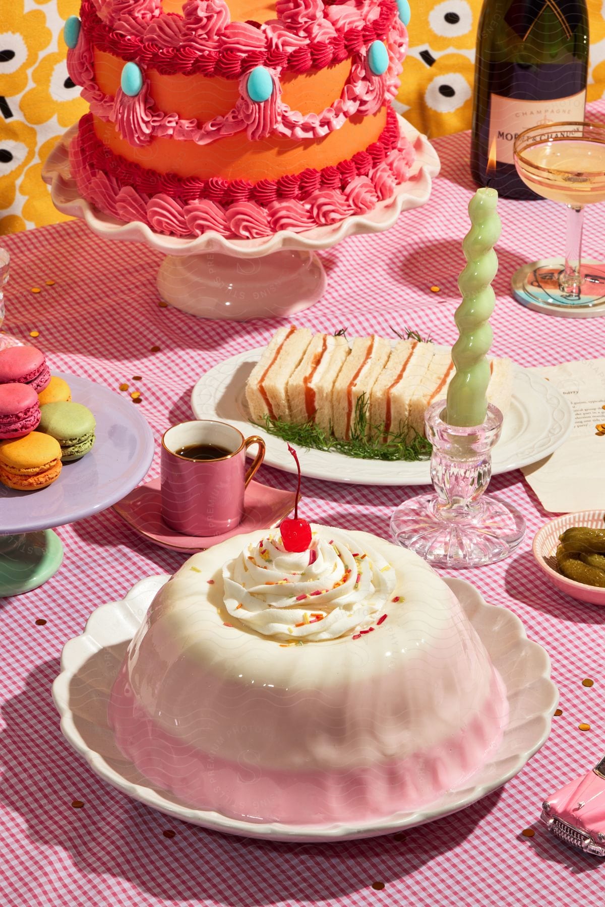 Stock photo of a set table with a birthday cake, white pudding, macaroons, finger sandwiches, coffee and white wine.