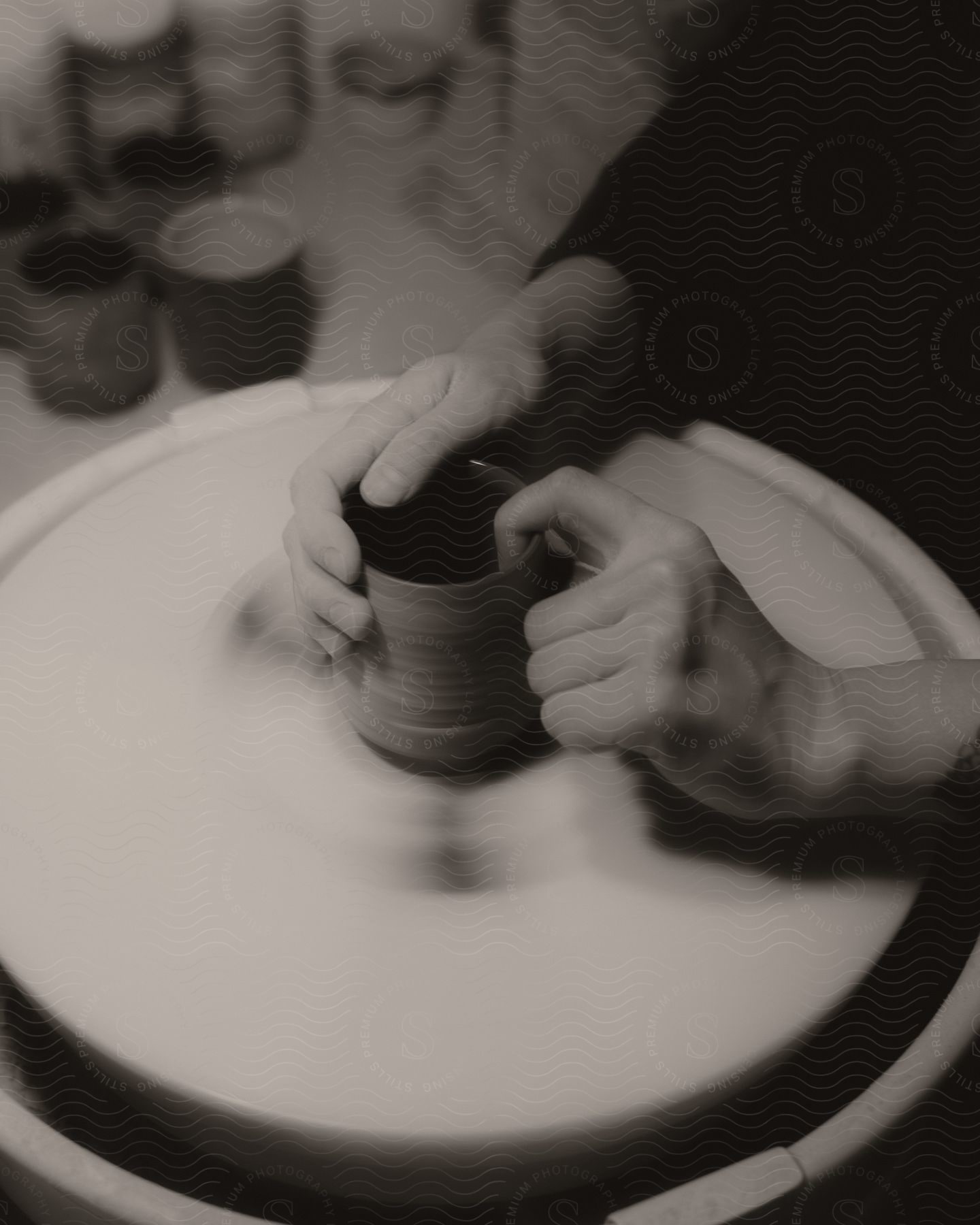 an artist makes a cup on a pottery wheel