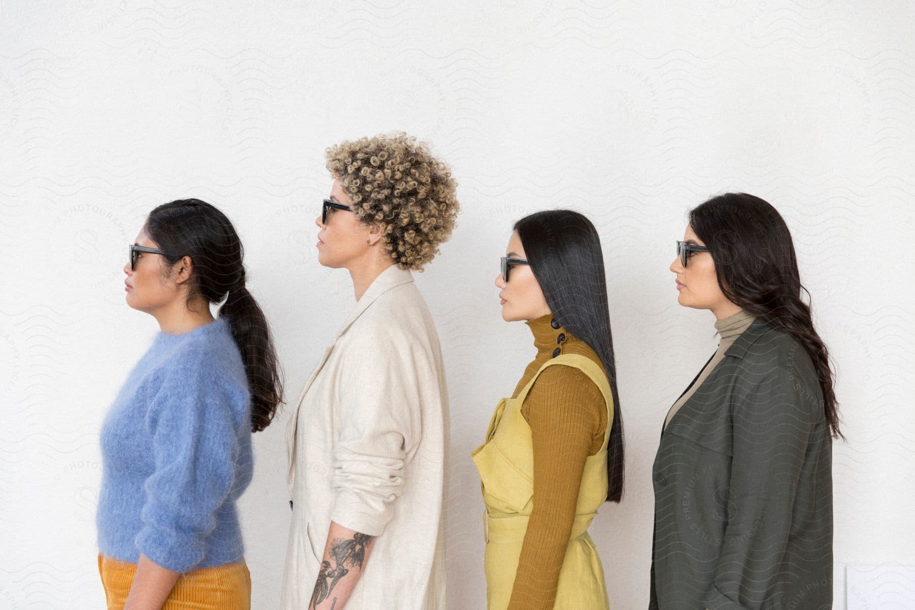 side profile of a group of female models wearing sunglasses jackets and sweaters