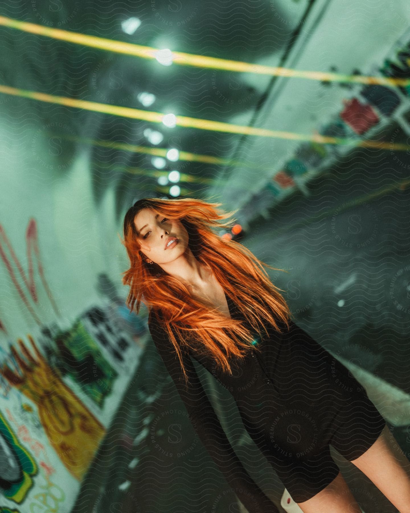 a woman stands in a tunnel marked with graffiti