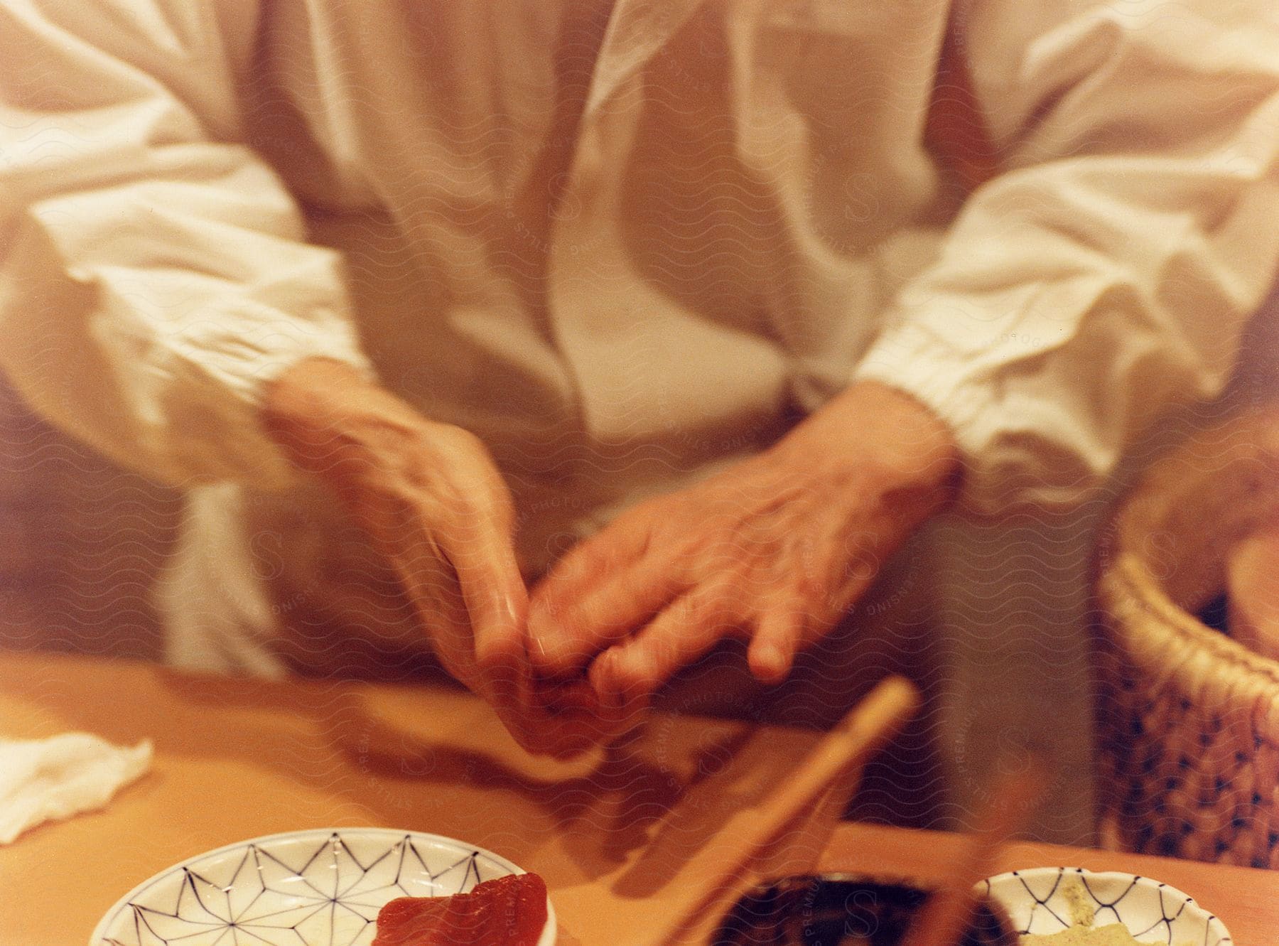 A sushi chef preparing sushi with raw tuna.