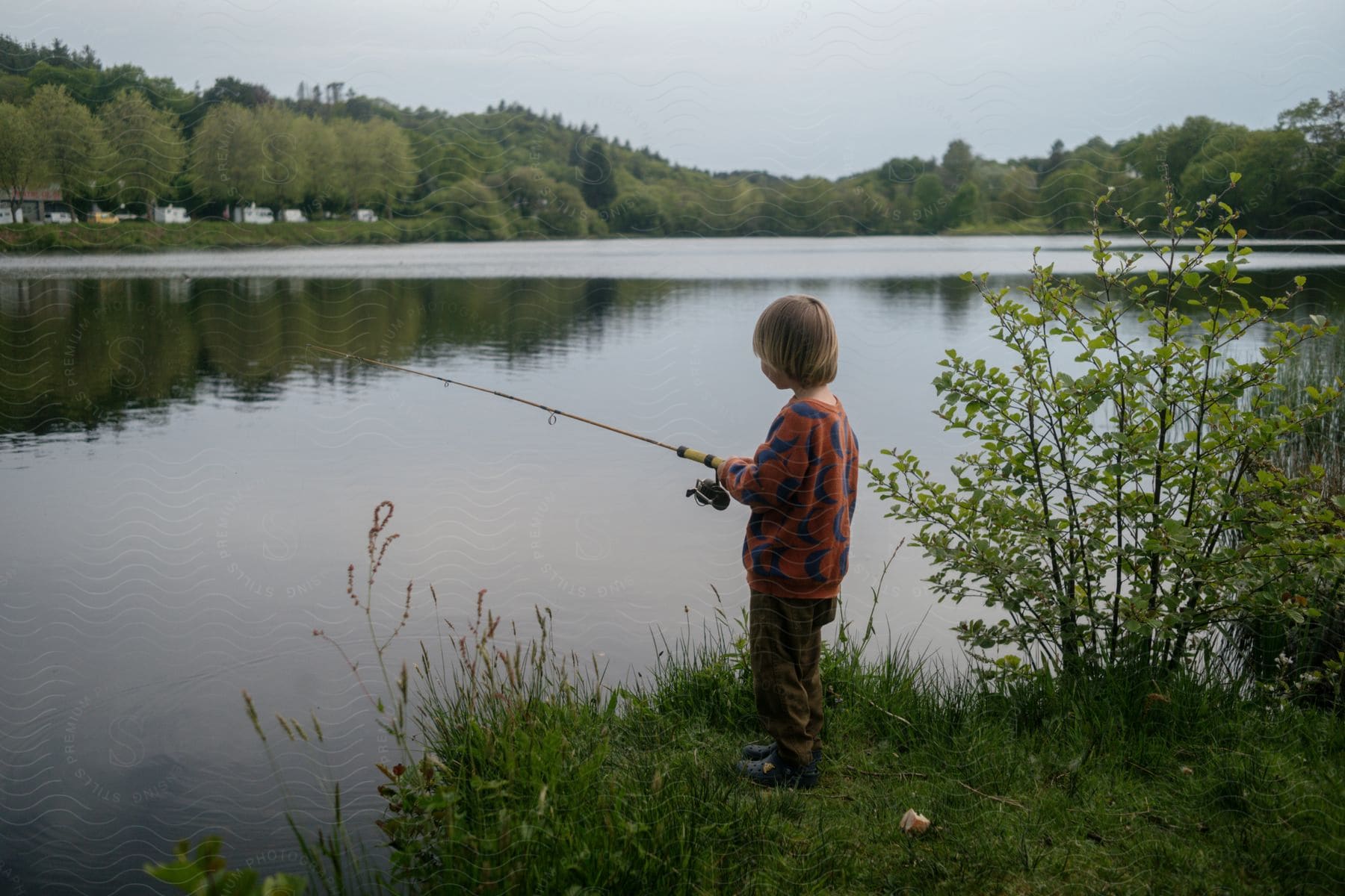 a boy fishes in a pond