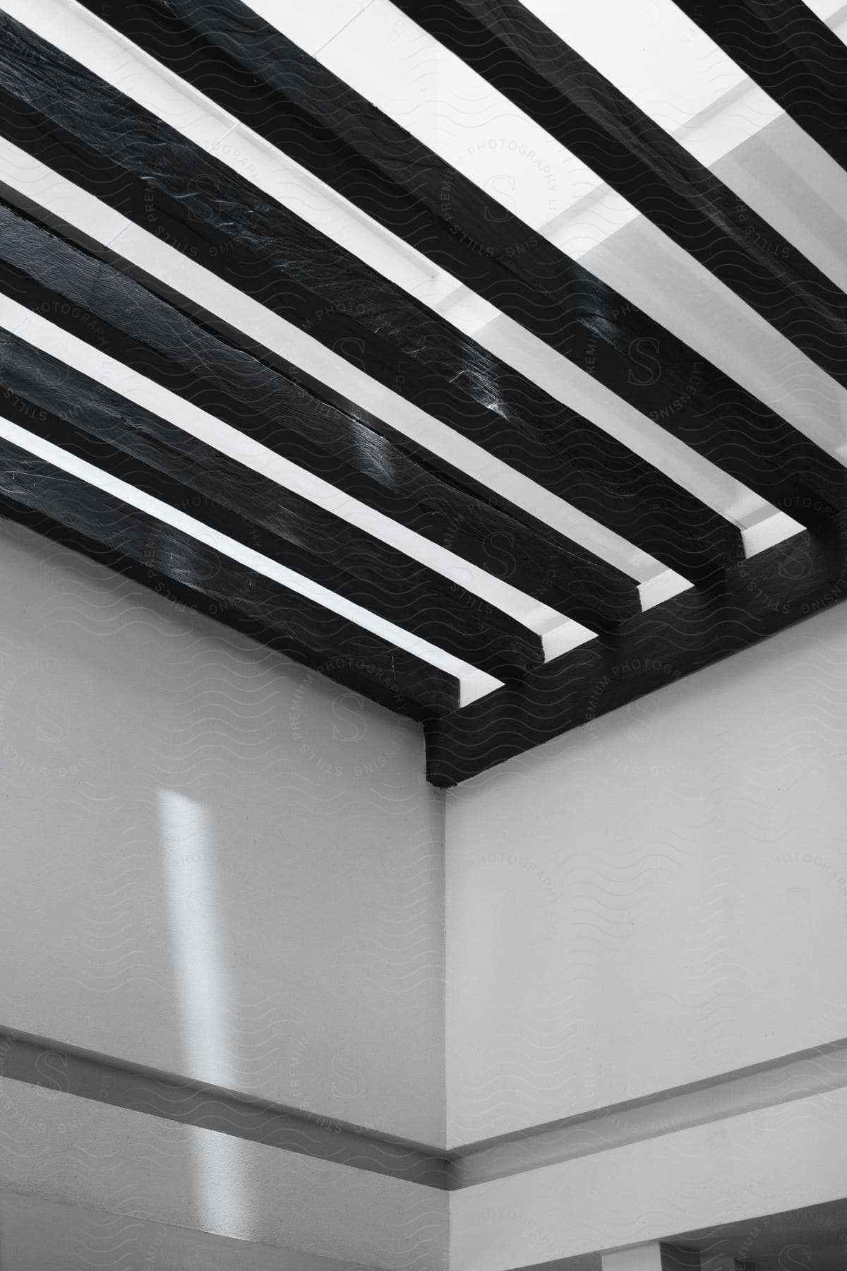 Exposed wooden beams support the ceiling under a skylight