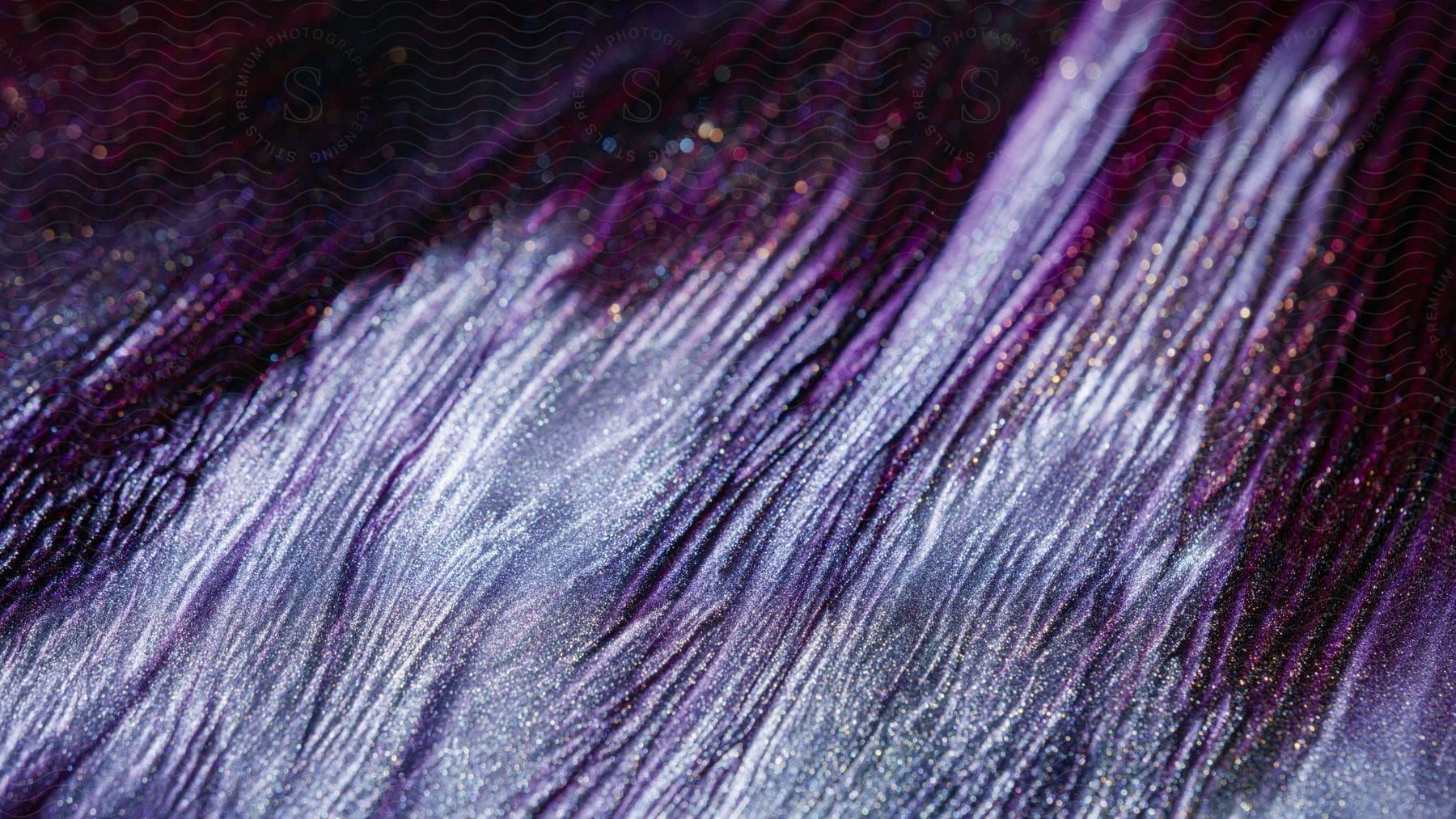 A close-up of shimmering purple and gold glitter texture.