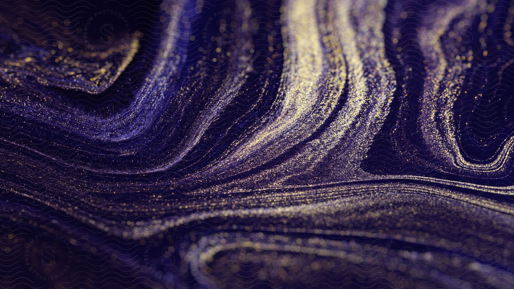 Stock photo of swirling fluid with purple and gold ink in it