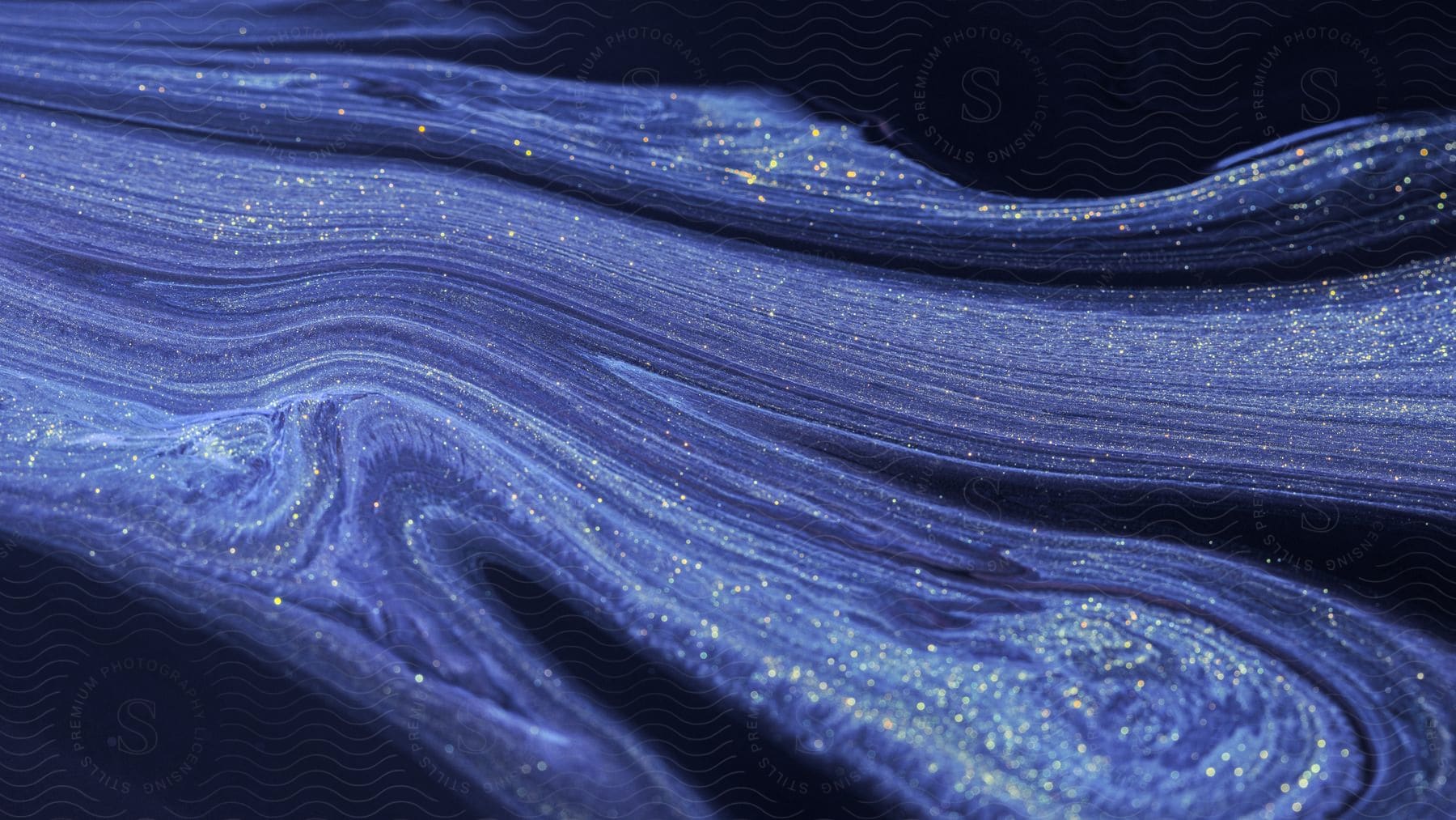 Abstract digital art of a fluid blue and white liquid with glitter