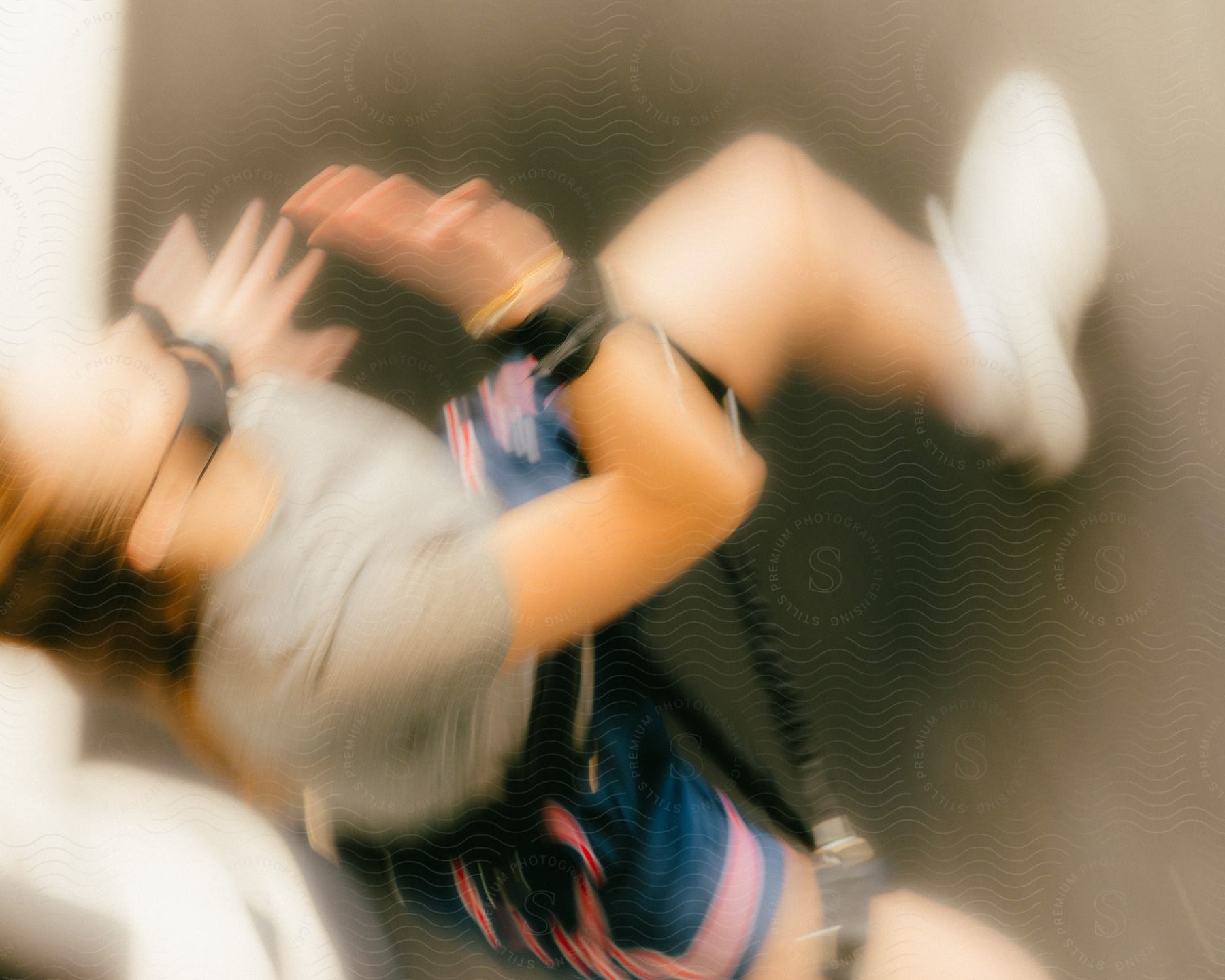 A young woman with fitness bands strapped to her arms and legs performs and exercise.