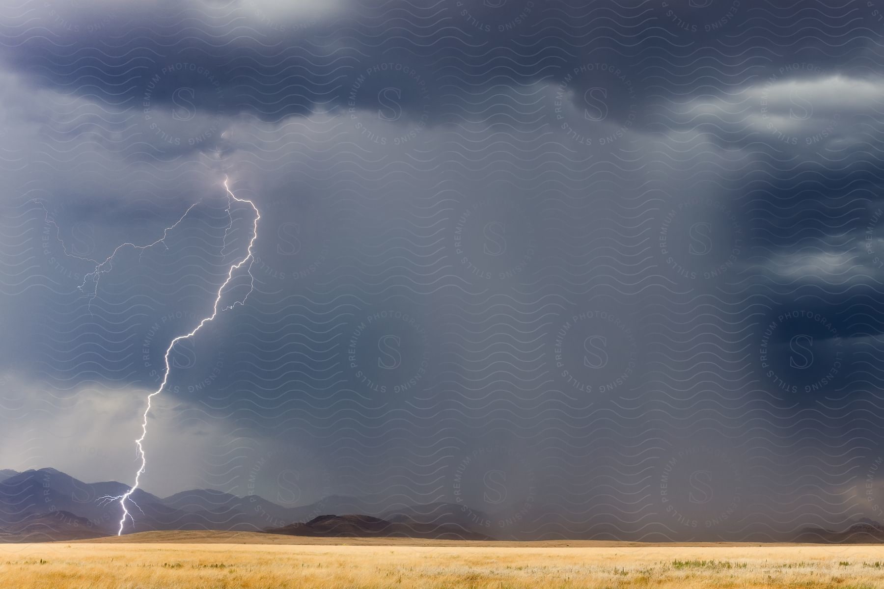 Storm clouds over a desert plain, with heavy rain and lightning.