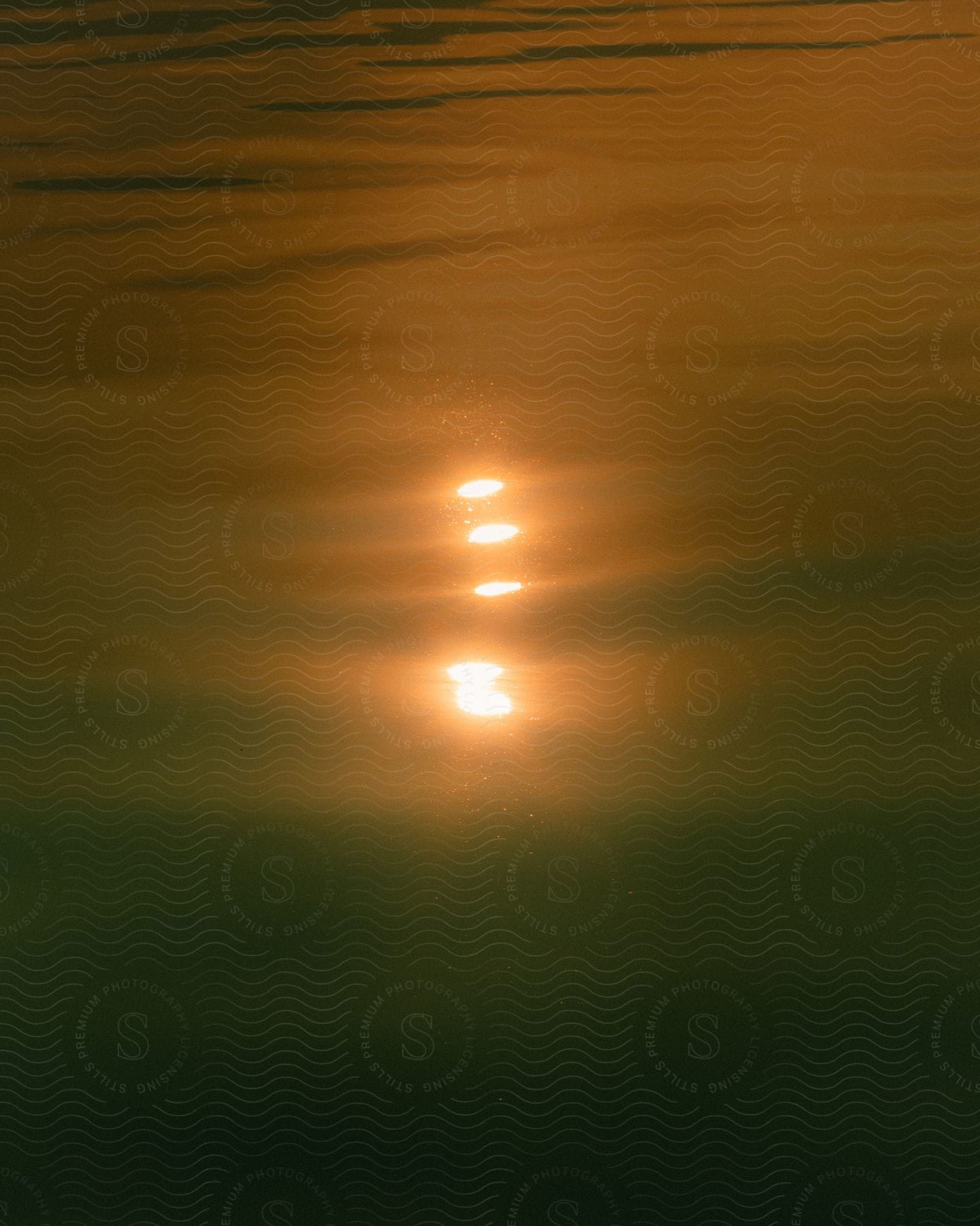 body of water at sunset with the sun reflecting off the water's surface