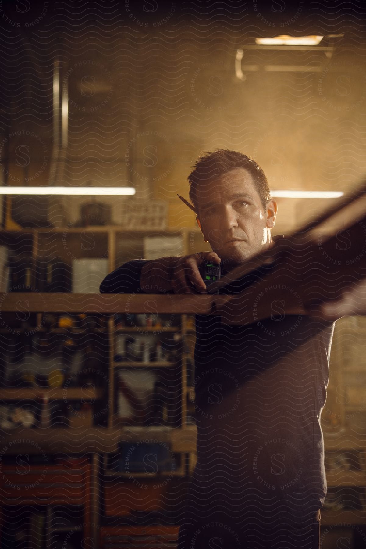 Stock photo of a man holds a measuring tape in his garage