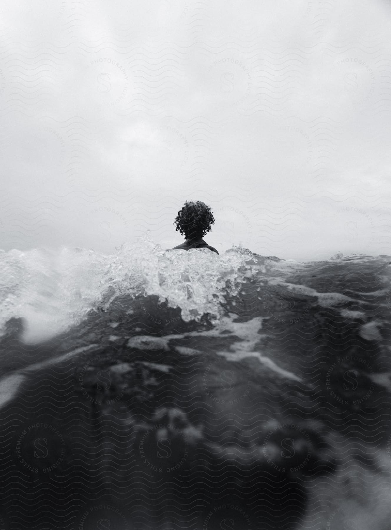 A Person Is In The Water As Waves Splash Behind Them