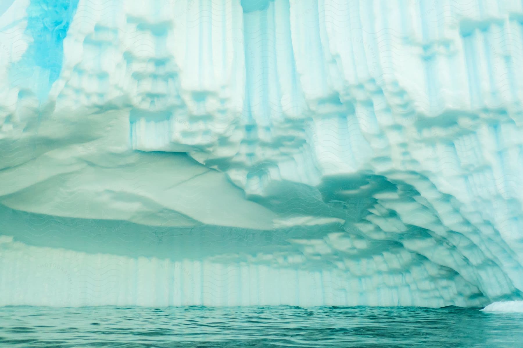 A large glacier made out of ice hanging out over some water