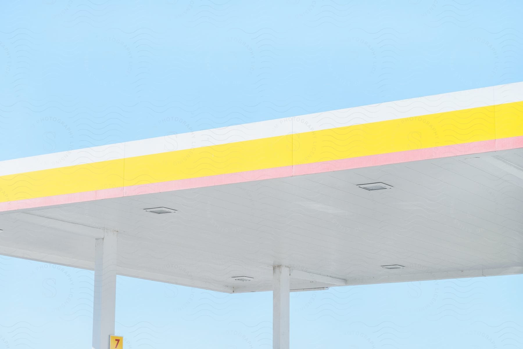 A gas station roof with yellow and white stripes on it