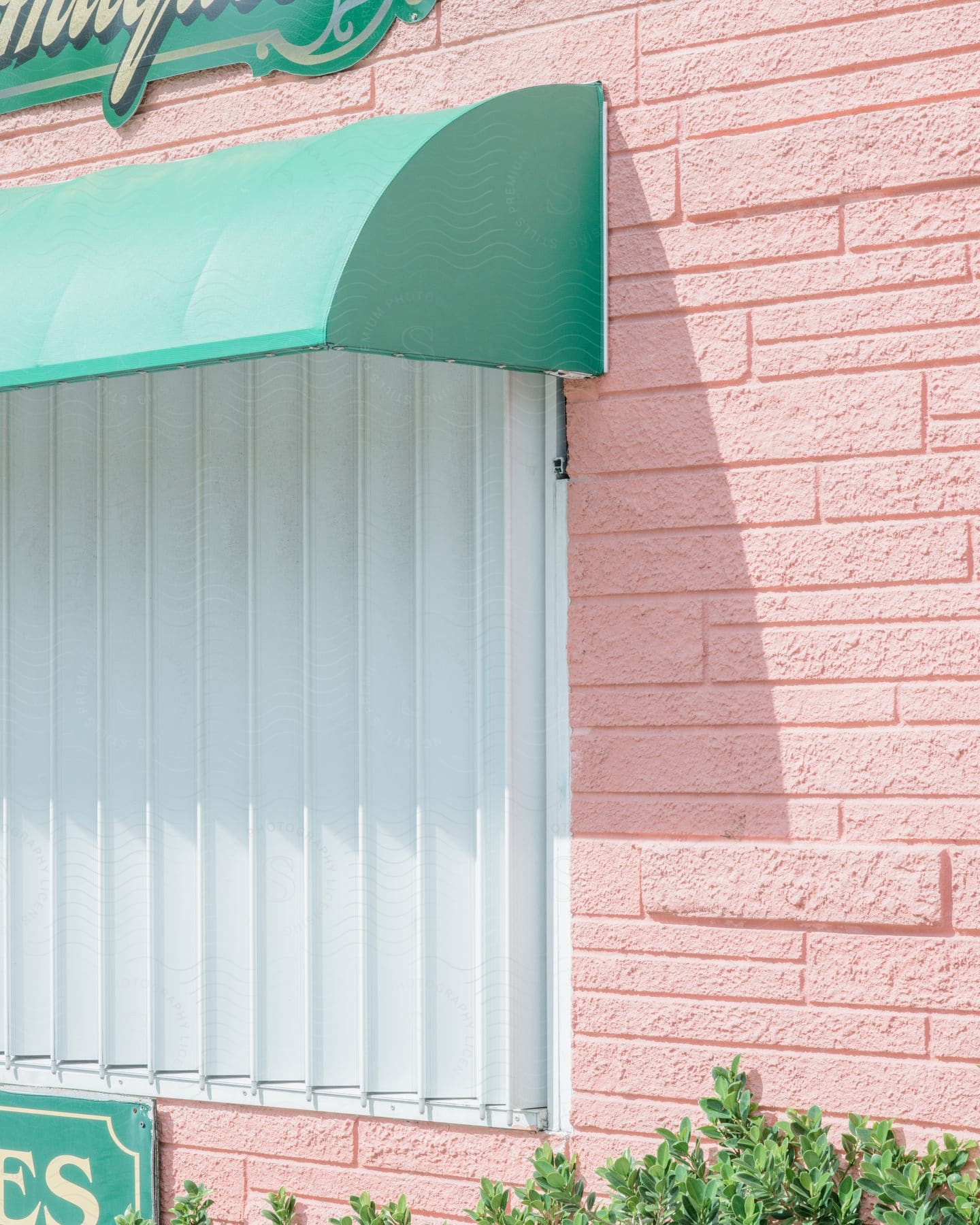 Exterior view of a building with pink walls and light blue Window Awnings