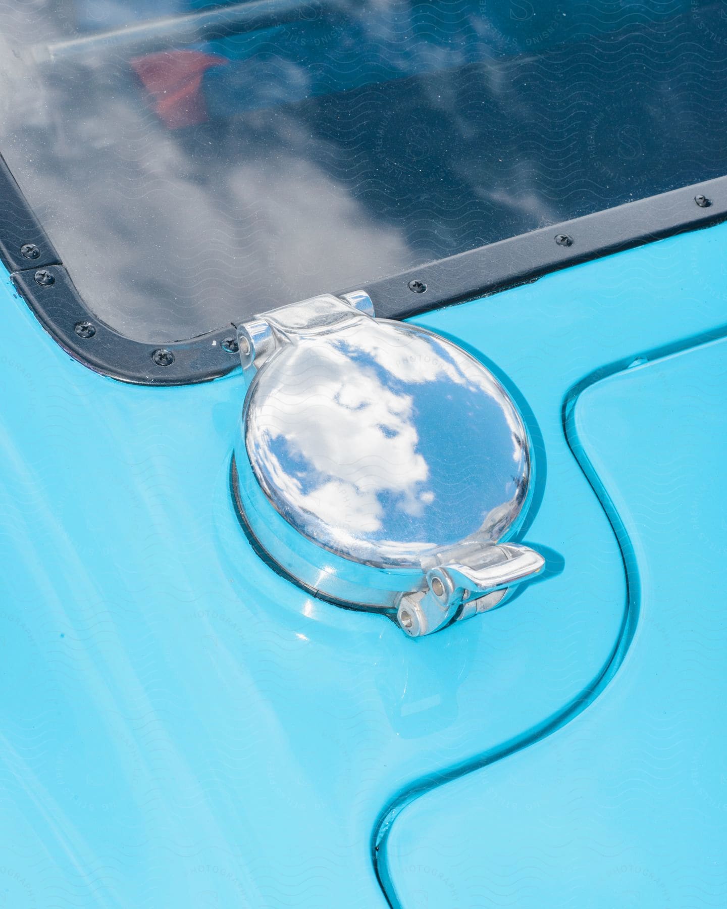 A chrome fuel tank cover on a light blue vehicle