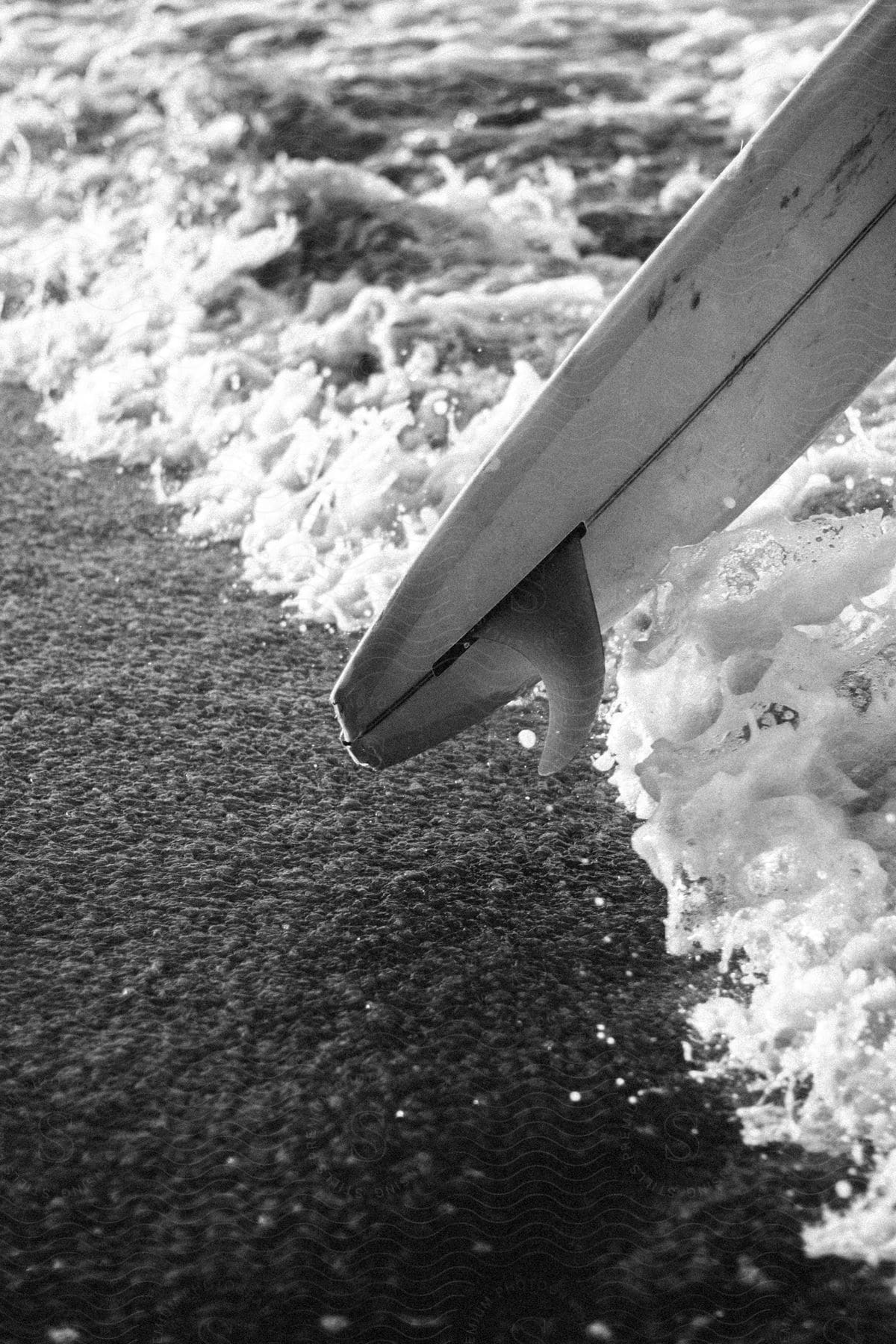 Black and white image a surfboard at the beach