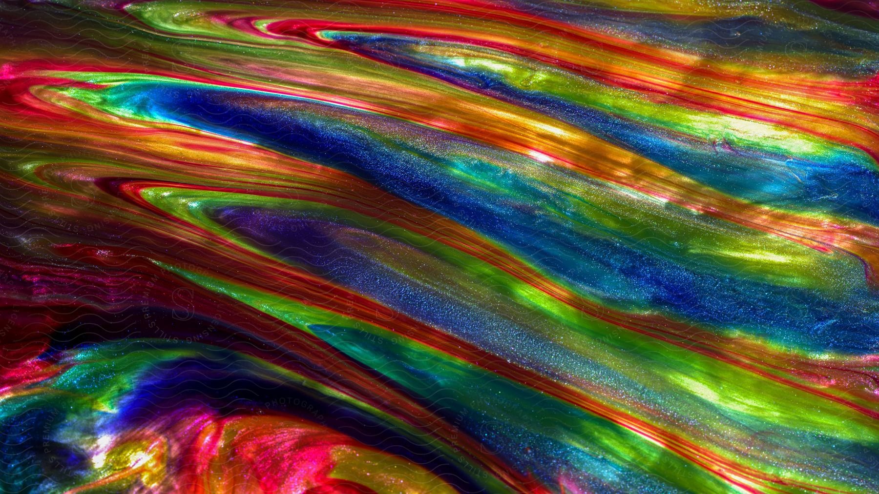 Numerous streaks and strands of different colored fluid are aligned to create a colorful abstract image.