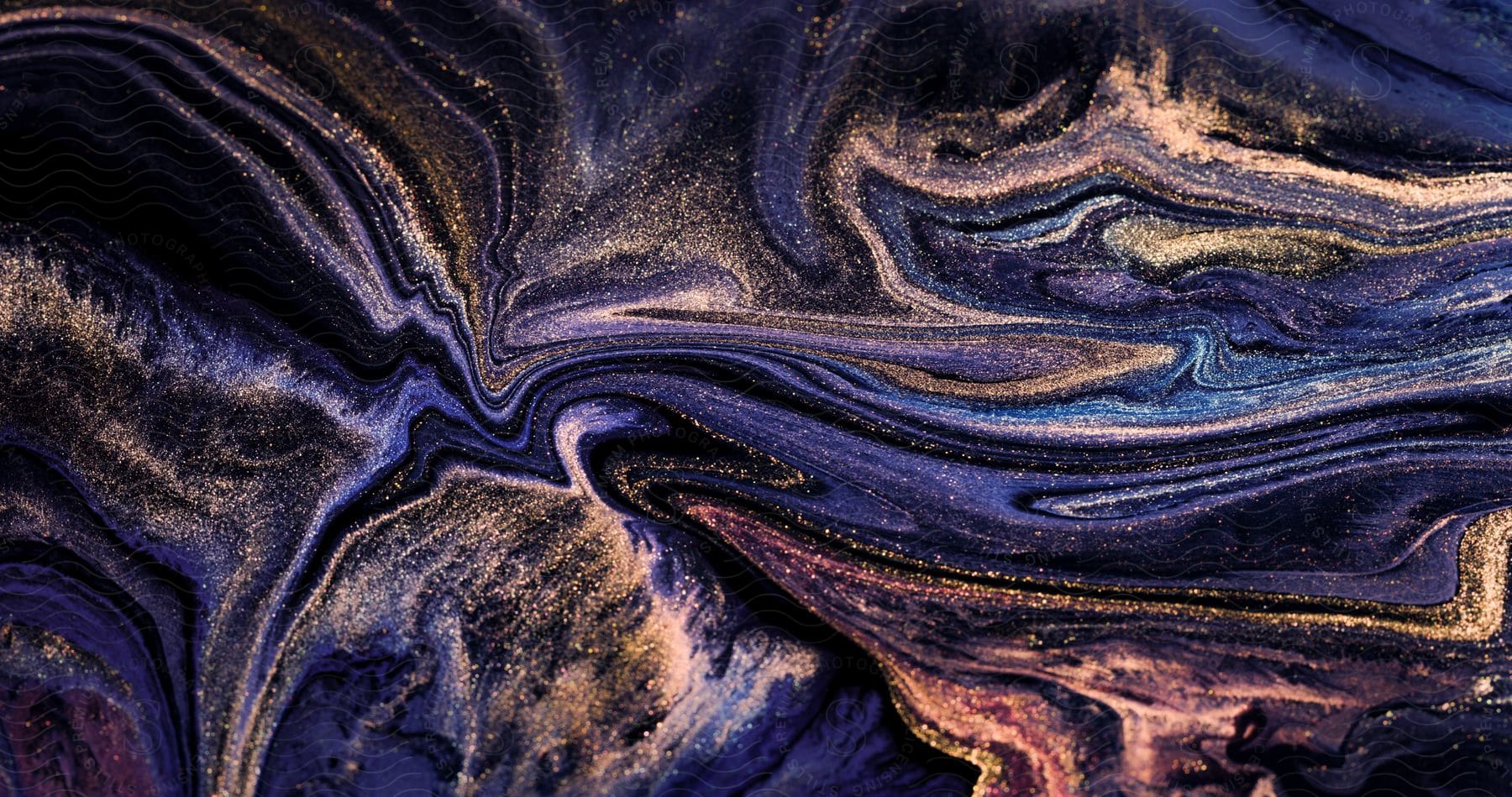 Abstract digital art of a swirling vortex of blue and purple liquid with gold dust glitter on a black background.