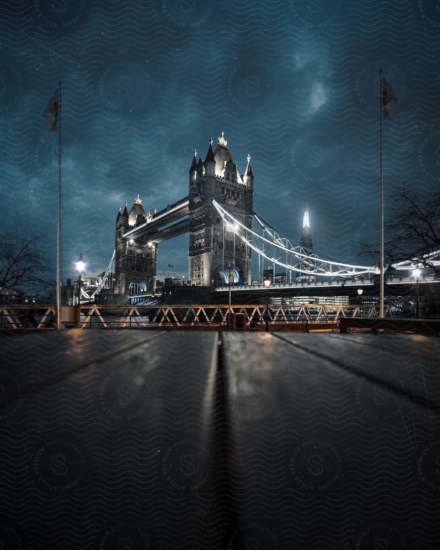 Stock photo of flags fly near the tower bridge in london under a dark cloudy sky