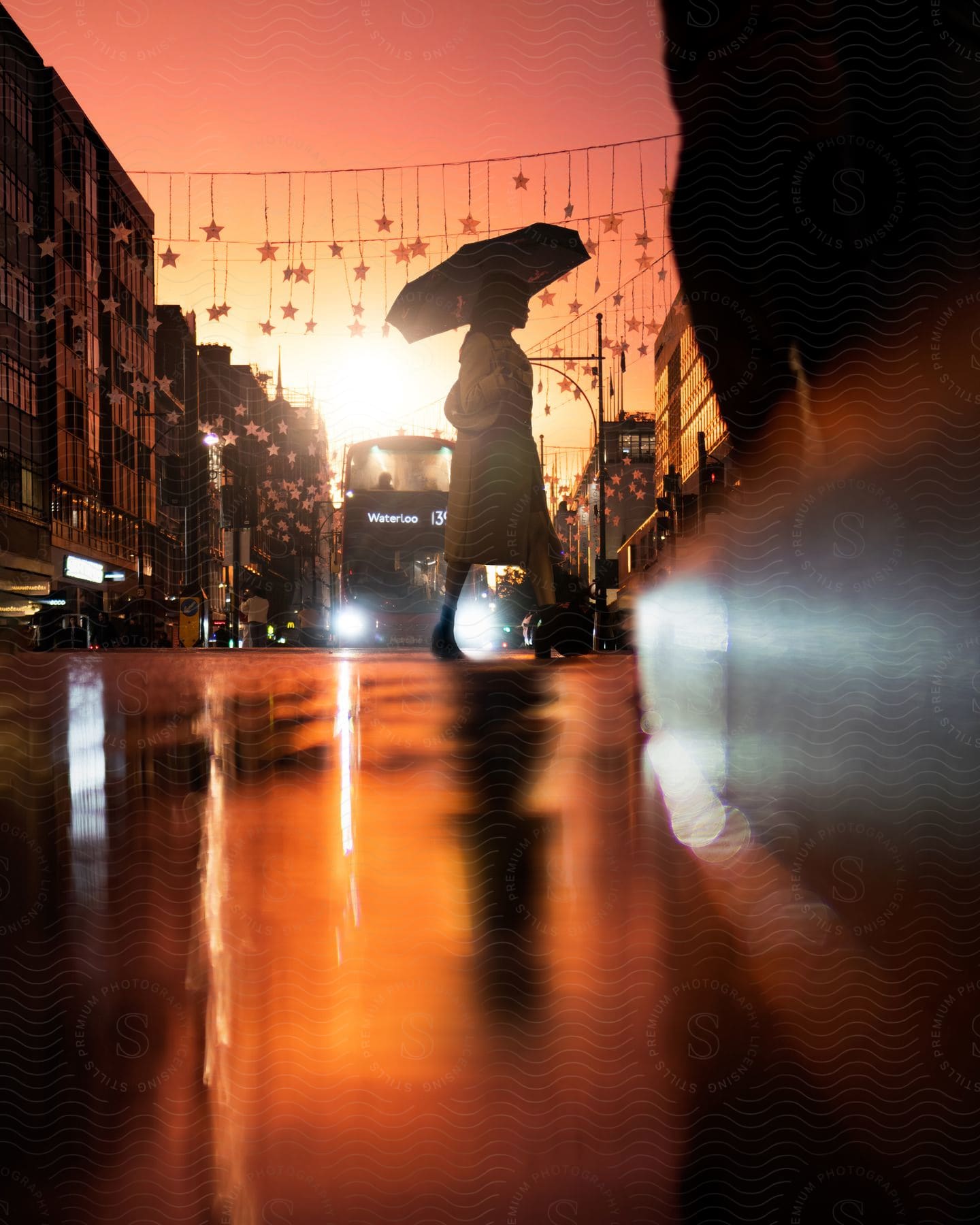 a woman uses an umbrella while crossing the street in a rainy city