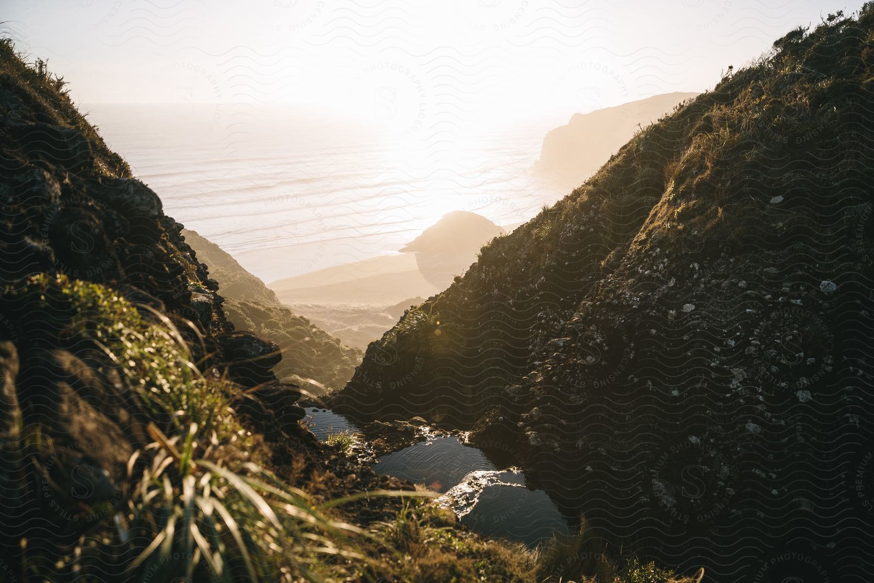 View of the sea coast with small natural pools and the dawn on the horizon.