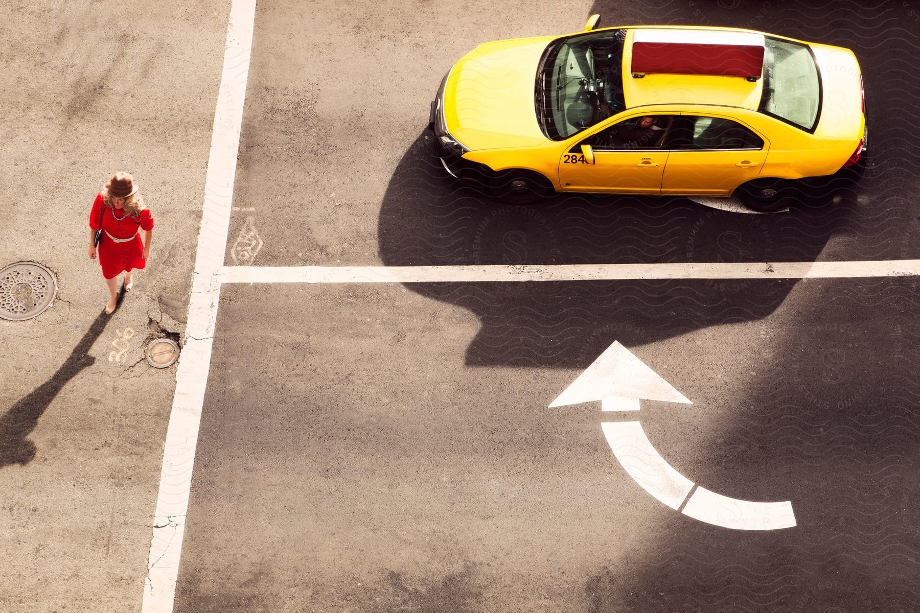 Aerial Of Woman Wearing Brown Hat And Red Dress Passes By A Taxi