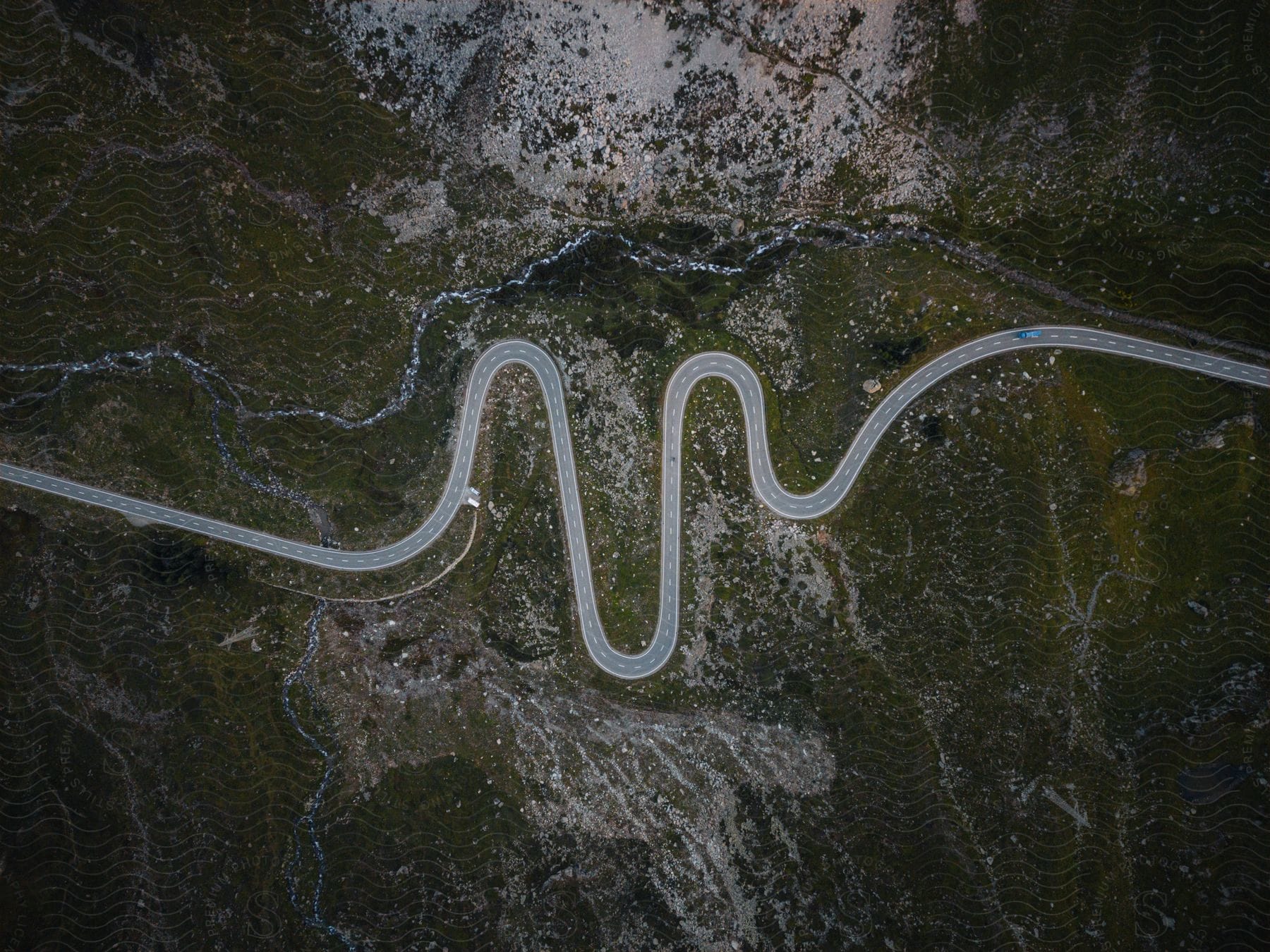 Stock photo of drone view of a winding road through a low mountainous region in a rural area