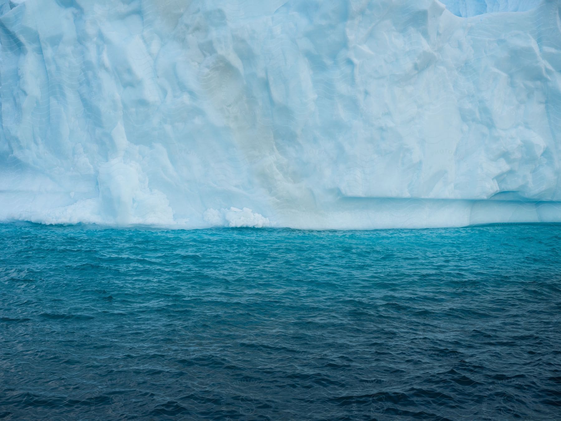 Melting glacier causes a cloud of snow on the ocean