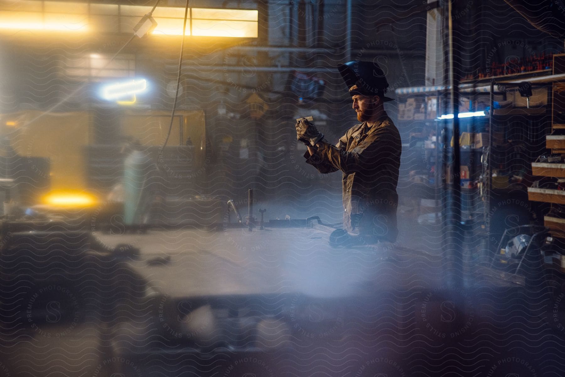 man inside the workshop holding a tool