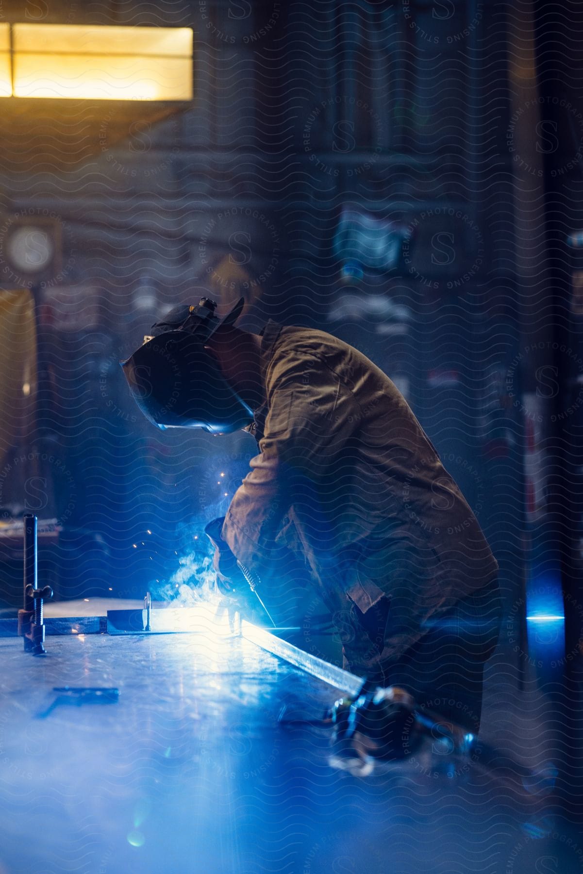 A man is welding in a workshop.