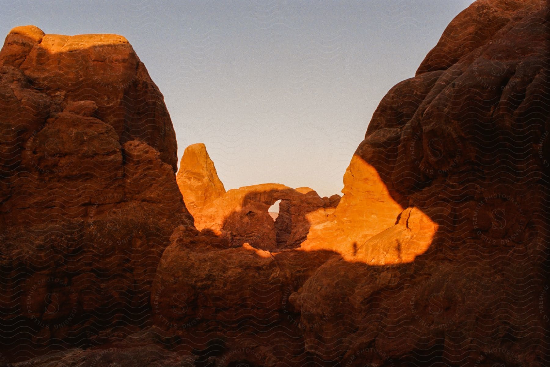 The sun shines on the rock arch bridge.