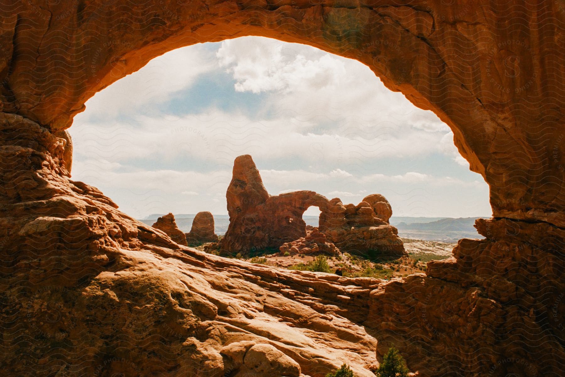 An arch of rock formations leads toward another rock formations overlooking the ocean.