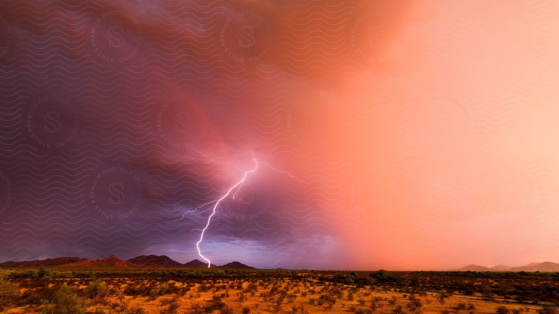 lightning strike in the desert as the red sky turns cloudy