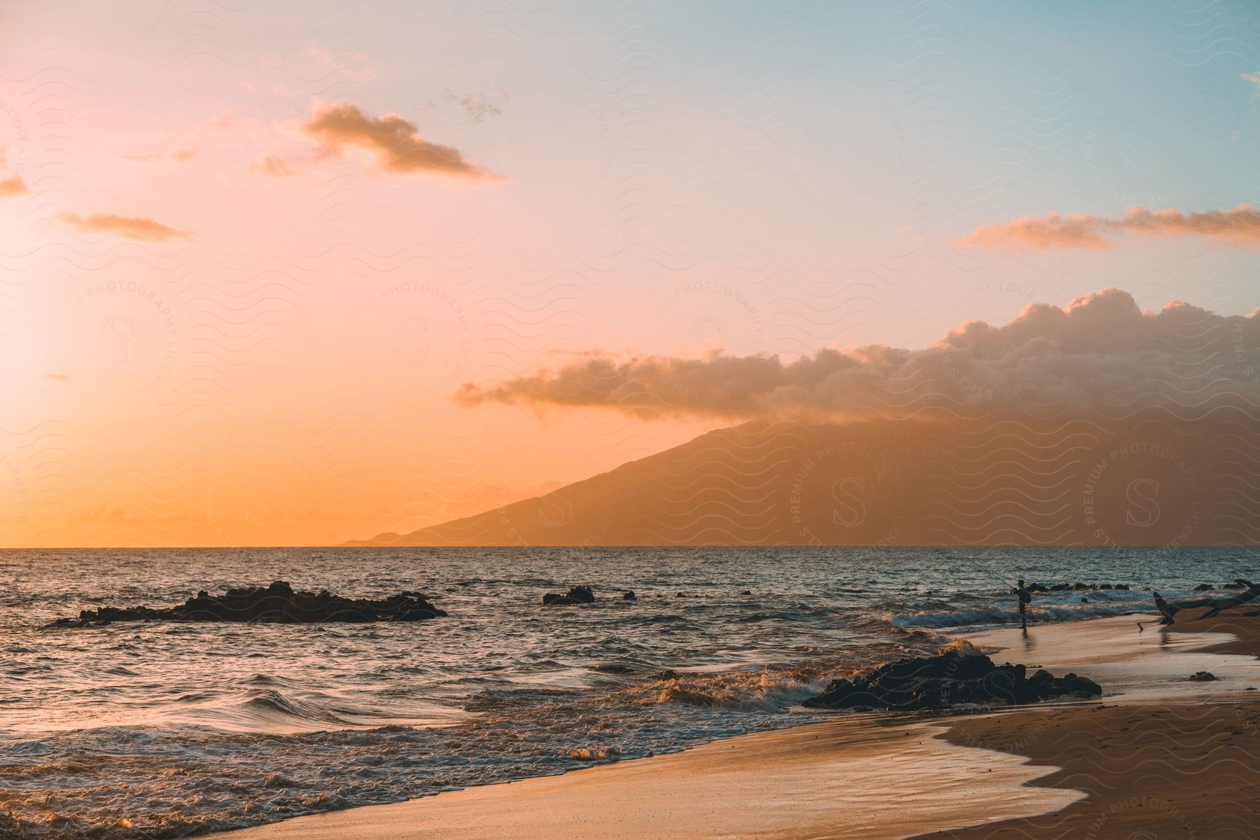 Beach shore with a cloudy sky at sunset.