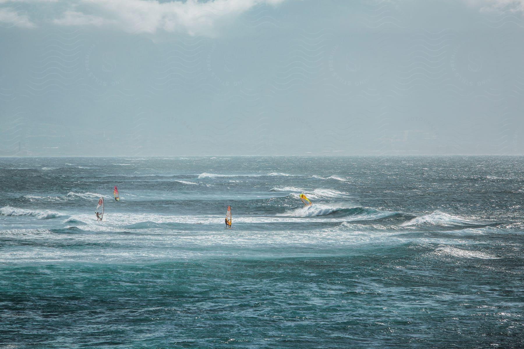 A group of people all surfing out in the ocean on waves.