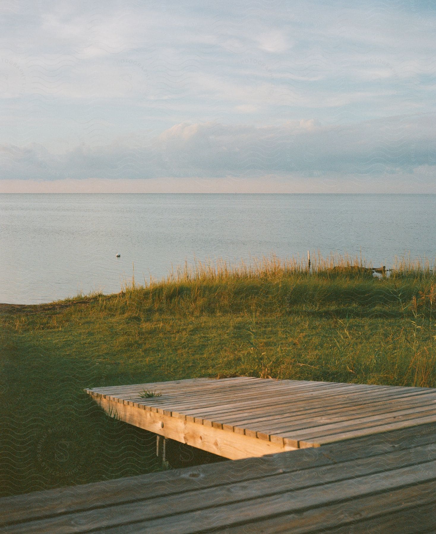 a wooden pier stops before the edge of a cliff over the ocean