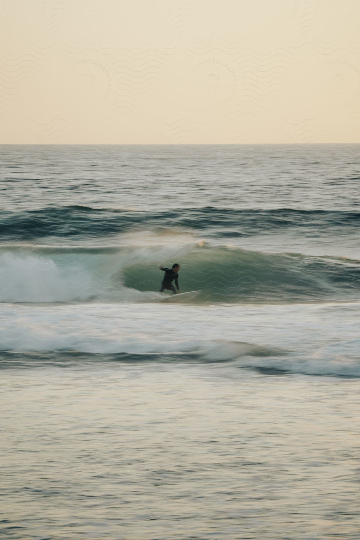 A surfer rides a wave, the whitewater crashing around them.