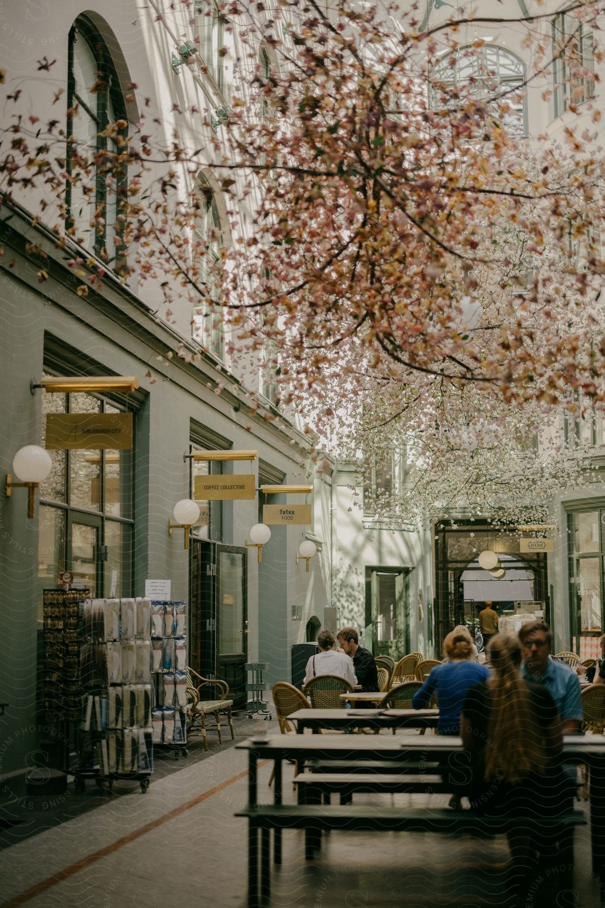 people sit at tables inside a shopping center