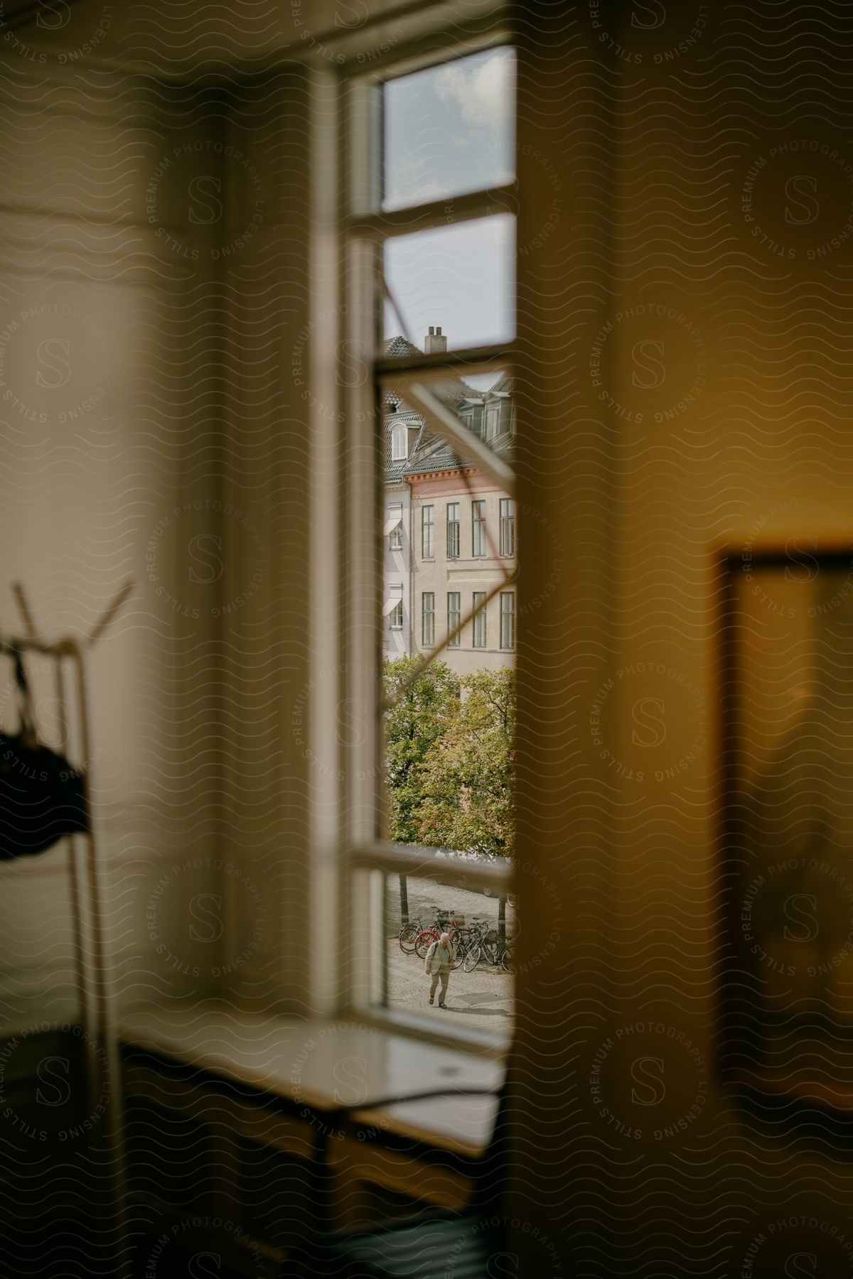 An Apartment Window Has Views Of Bicycles Chained To A Rack