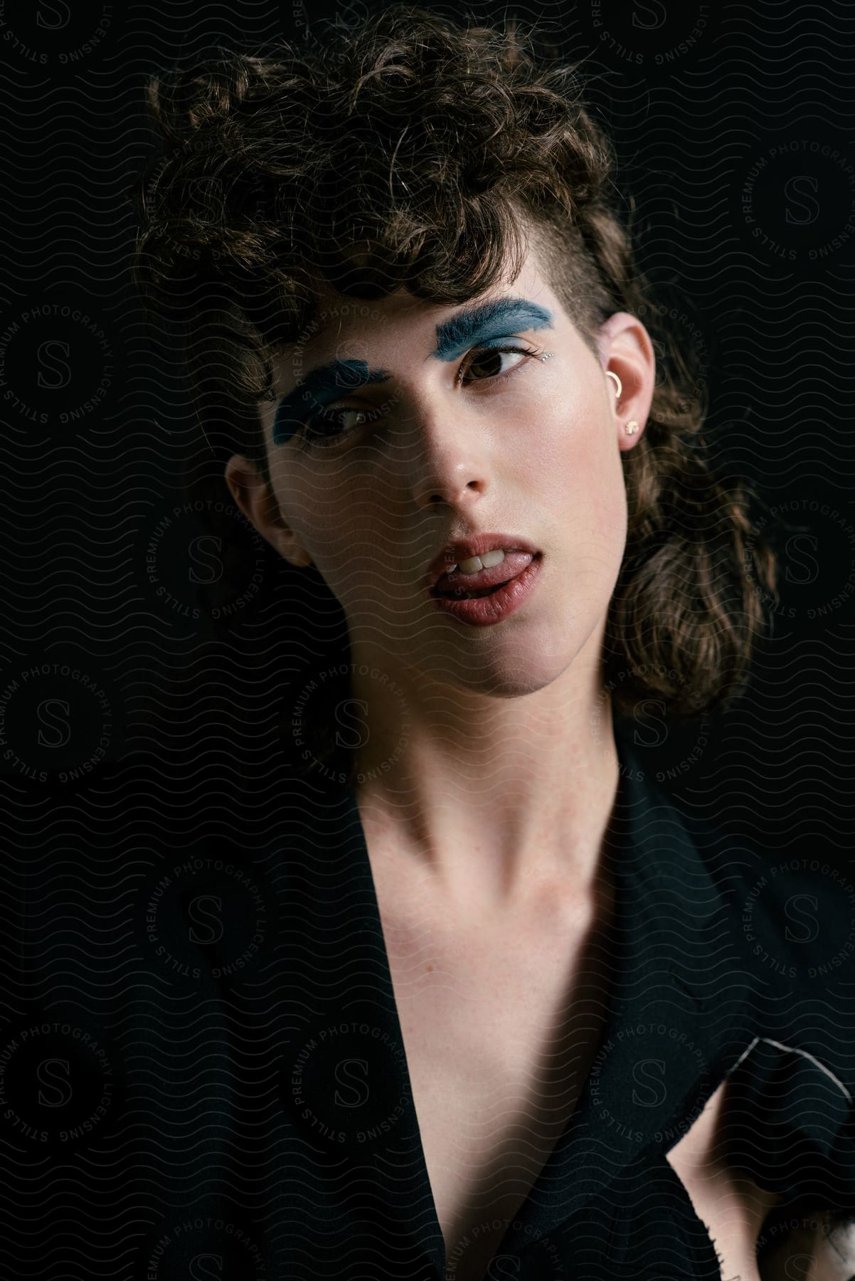 Androgynous person poses for portrait with mouth a gap