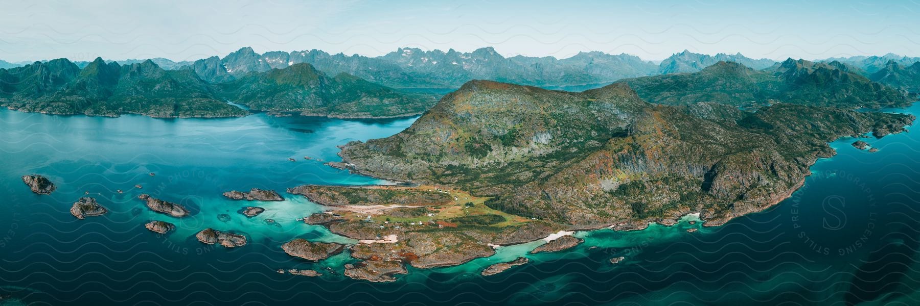 Aerial view of a turquoise blue sea surrounded by mountains.