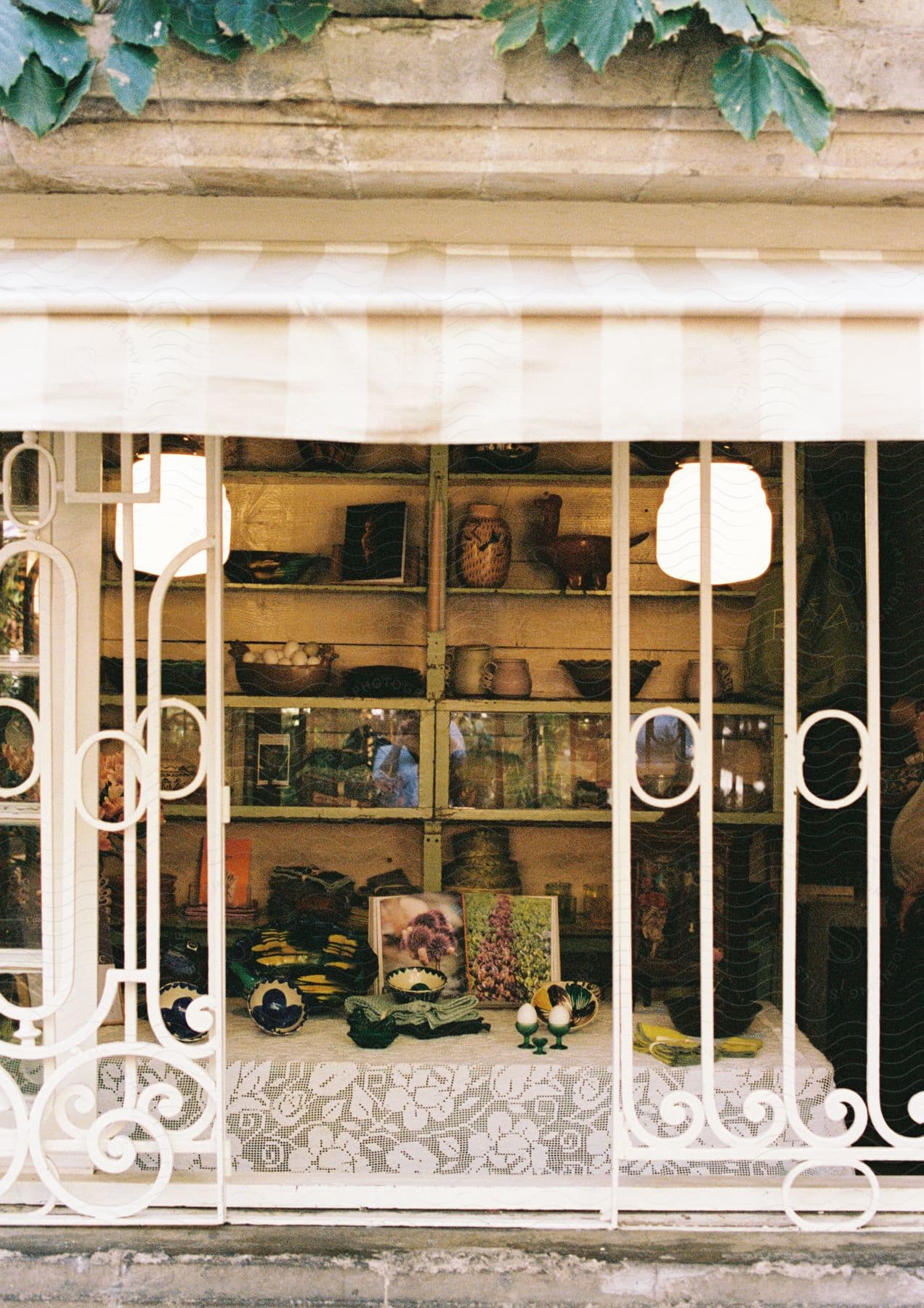 Stock photo of window shop on a store next to the sidewalk with the reflection in the window glass a person taking a photograph during day time