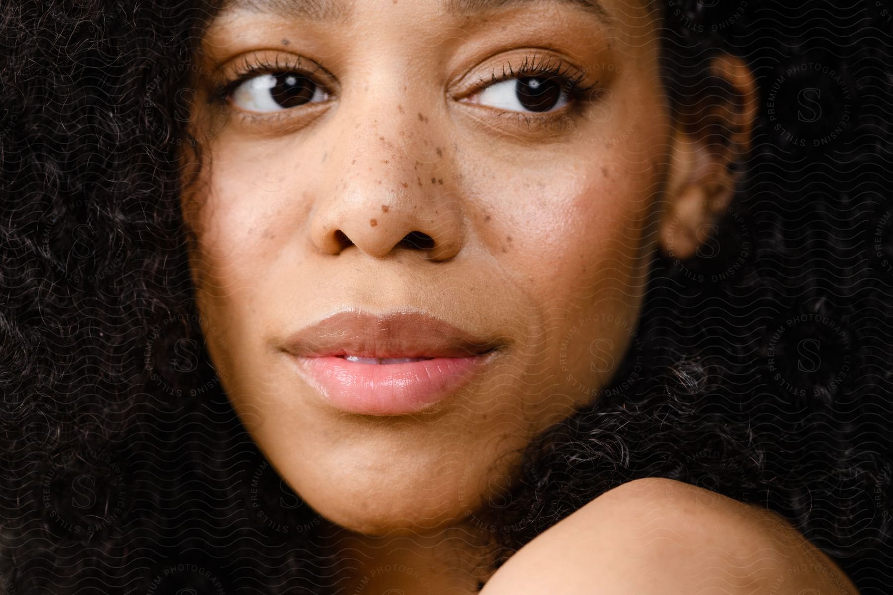 Portrait of a young woman with curly hair.