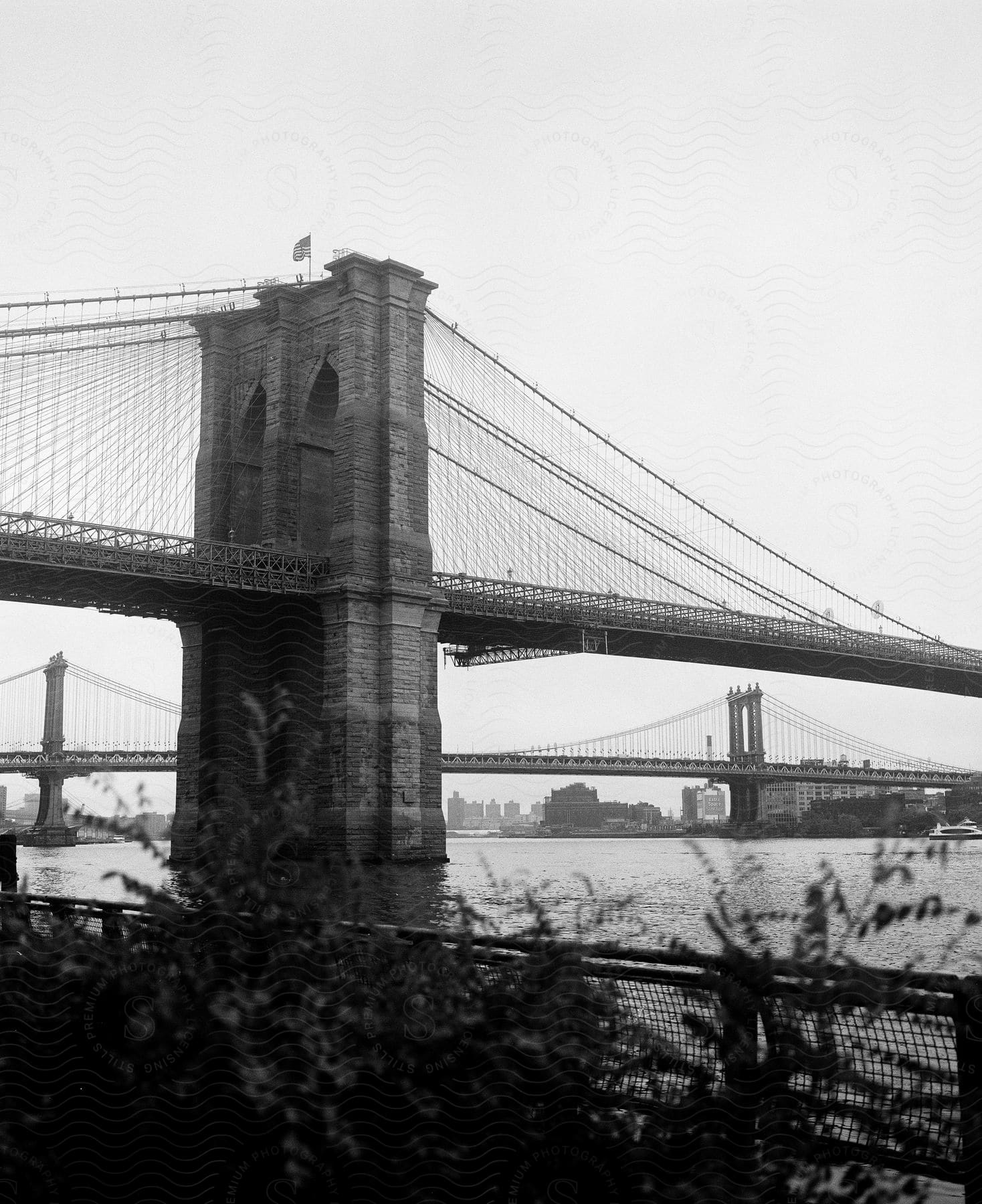 The Brooklyn Bridge appears in the foreground with the Manhattan Bridge in the background as they cross the East River.