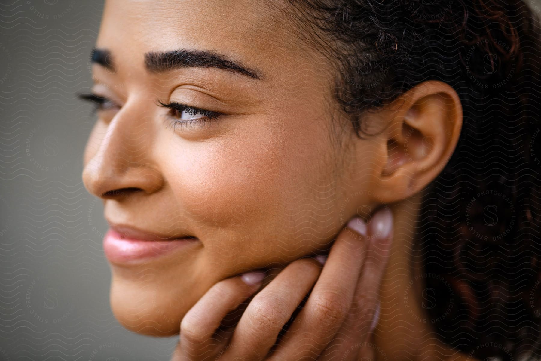 A woman is smirking as she stares off to the side.