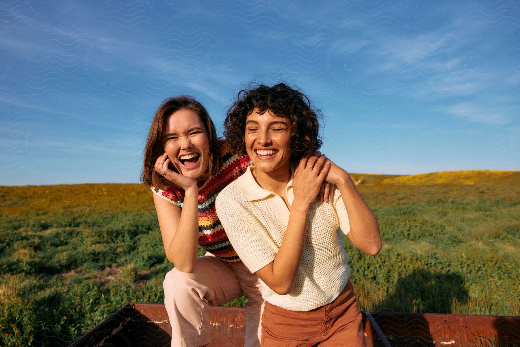 Friends smile while standing together in rusty truck bed