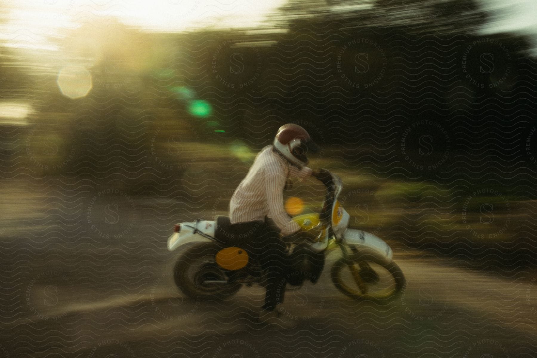 a person wearing a helmet while riding a dirt bike on the sand